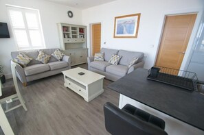 Relax in this stylish living room with two sofas, a coffee table, and a wooden cabinet.