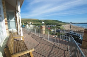 Enjoy the serene beach views from this balcony with a comfortable bench.