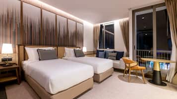 Ein Hotelzimmer mit zwei Betten, einem kleinen Tisch und einem Stuhl.