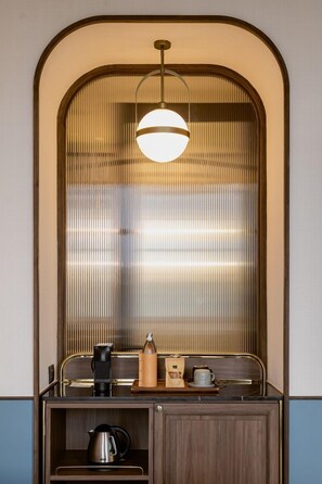 Enjoy a convenient coffee station with kettle, coffee maker, and tray in this compact kitchenette.