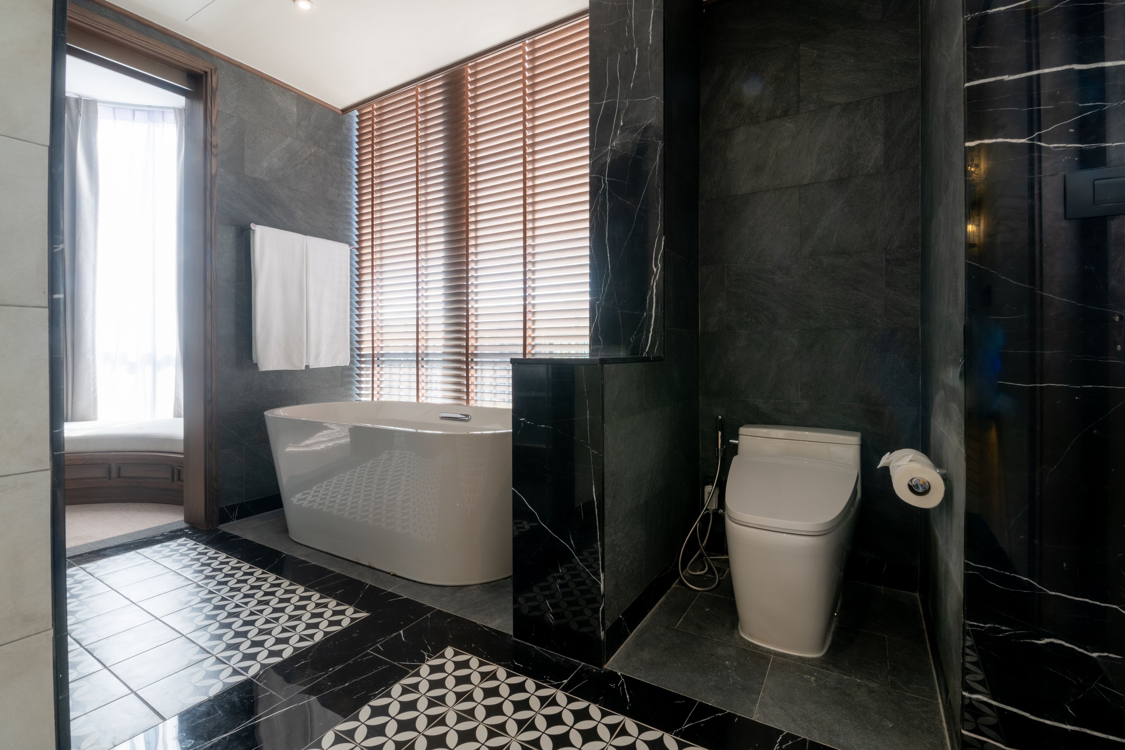 A modern bathroom with a freestanding bathtub, a toilet, and a shower area.