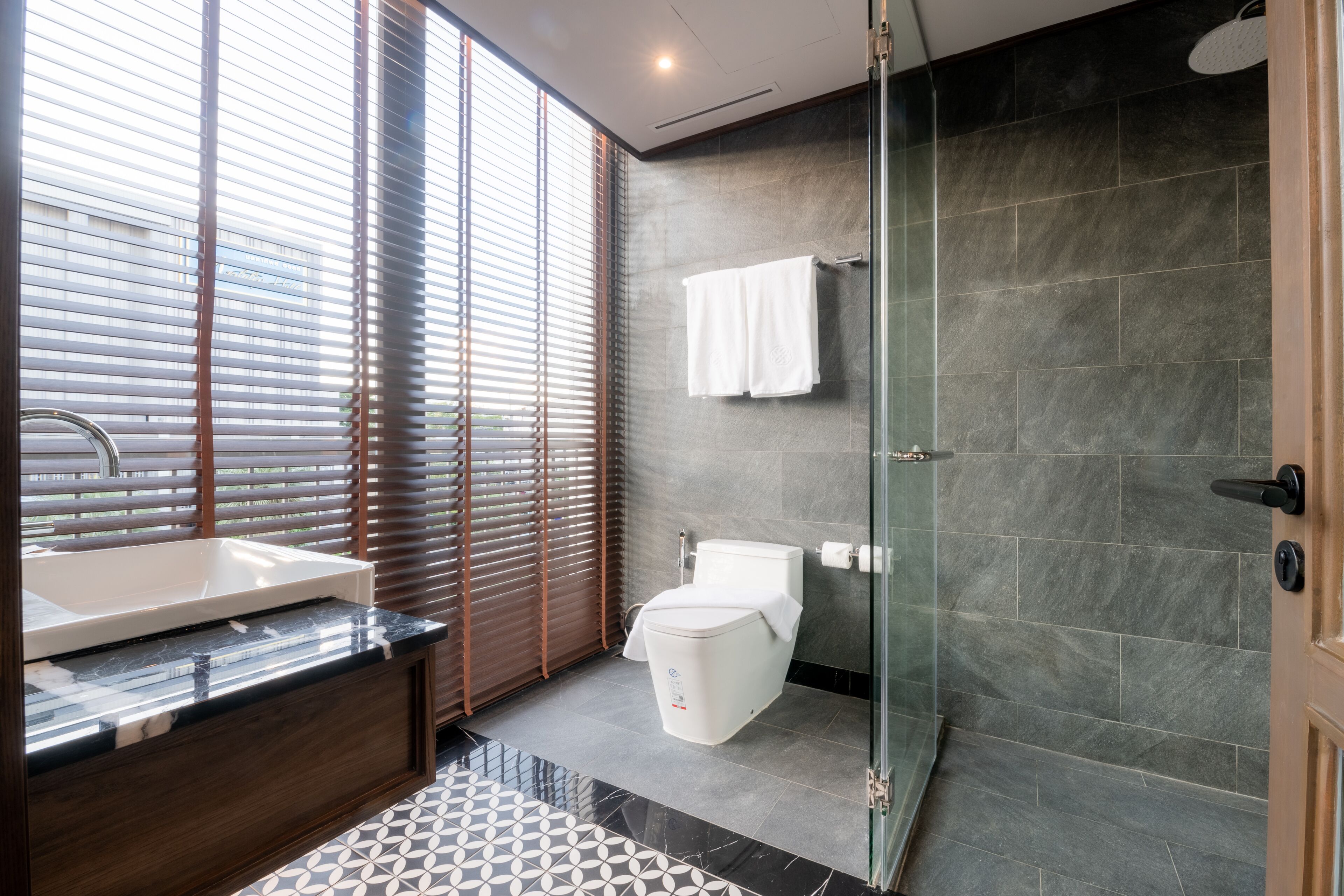 Un baño moderno con una bañera grande, inodoro y zona de ducha.