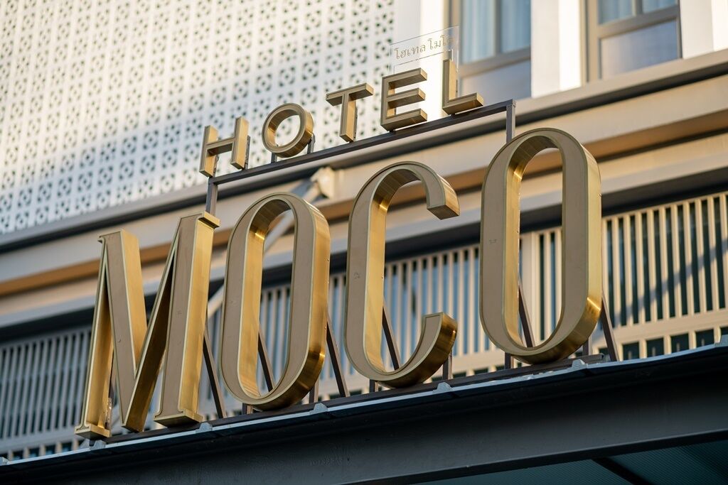 A hotel sign with the name "HOTEL MOCCO" in large, gold letters.