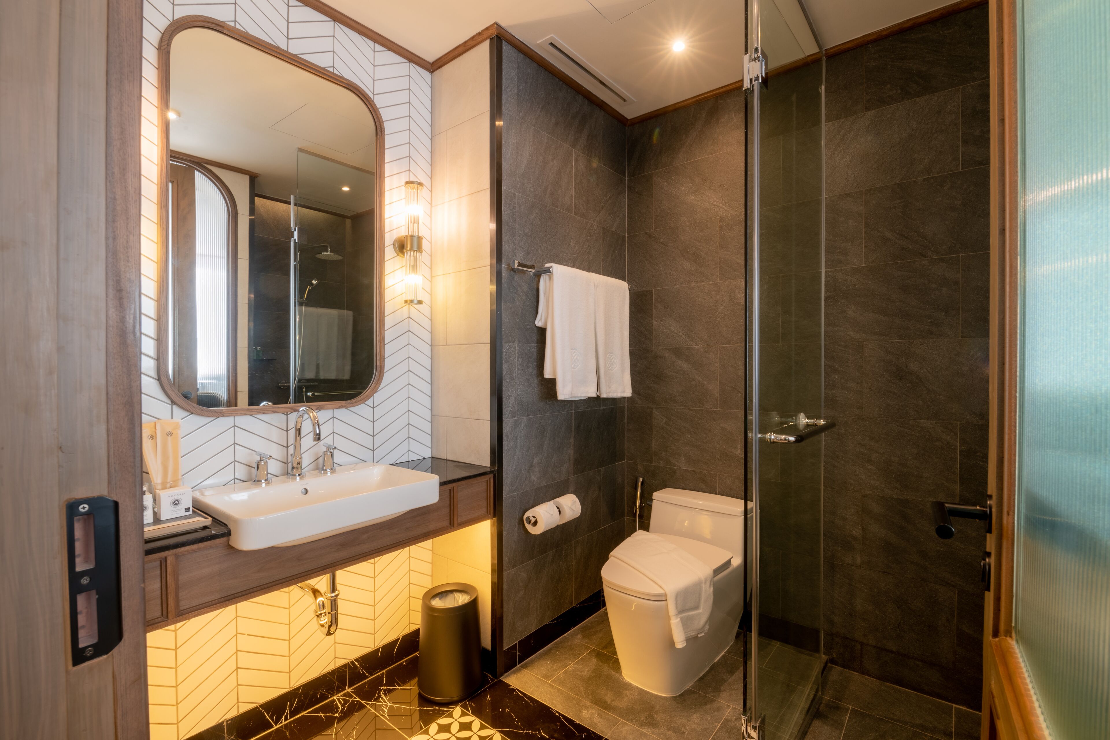 Une salle de bain moderne avec une douche à parois de verre, un lavabo blanc et des toilettes.