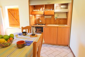 A compact kitchen with wooden cabinets, a stove, and a sink.