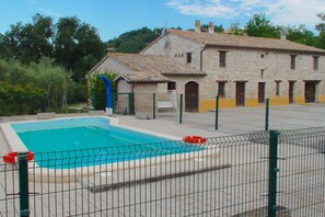 A swimming pool with a stone building in the background.