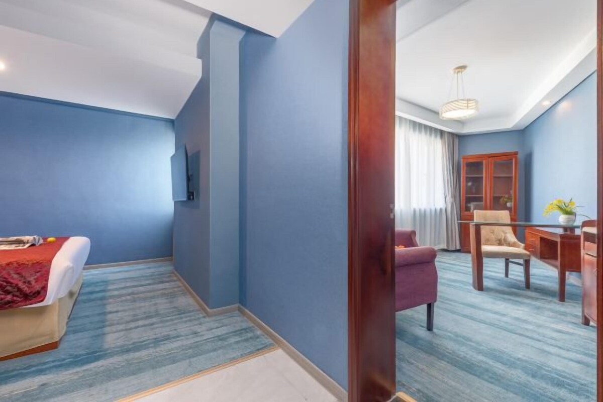 Een hotelkamer met een bed, bureau, stoel en televisie.