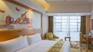 A hotel room with a bed, a desk, a chair, and a window with curtains. - Vienna International Hotel (Kunshan Qingyang North Road Wanda) (Suzhou)