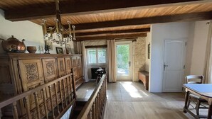 Un interior de madera con una escalera, un comedor y vistas a través de una ventana.