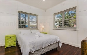 Simple, serene space with a single bed, nightstand, and natural light.