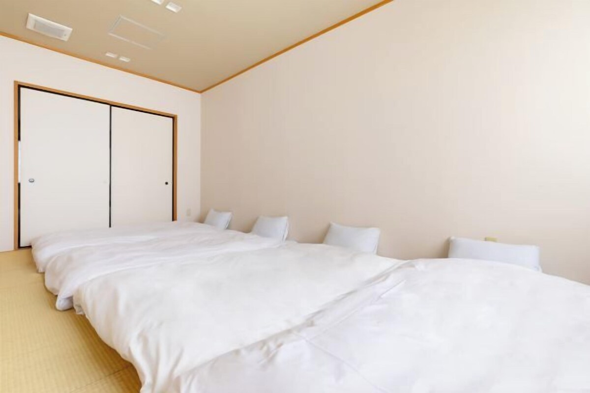 A hotel room with a large bed, a wardrobe, and a ceiling light fixture.