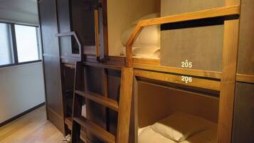 A room with bunk beds labeled 205 and 206, wooden shelving, and a window.