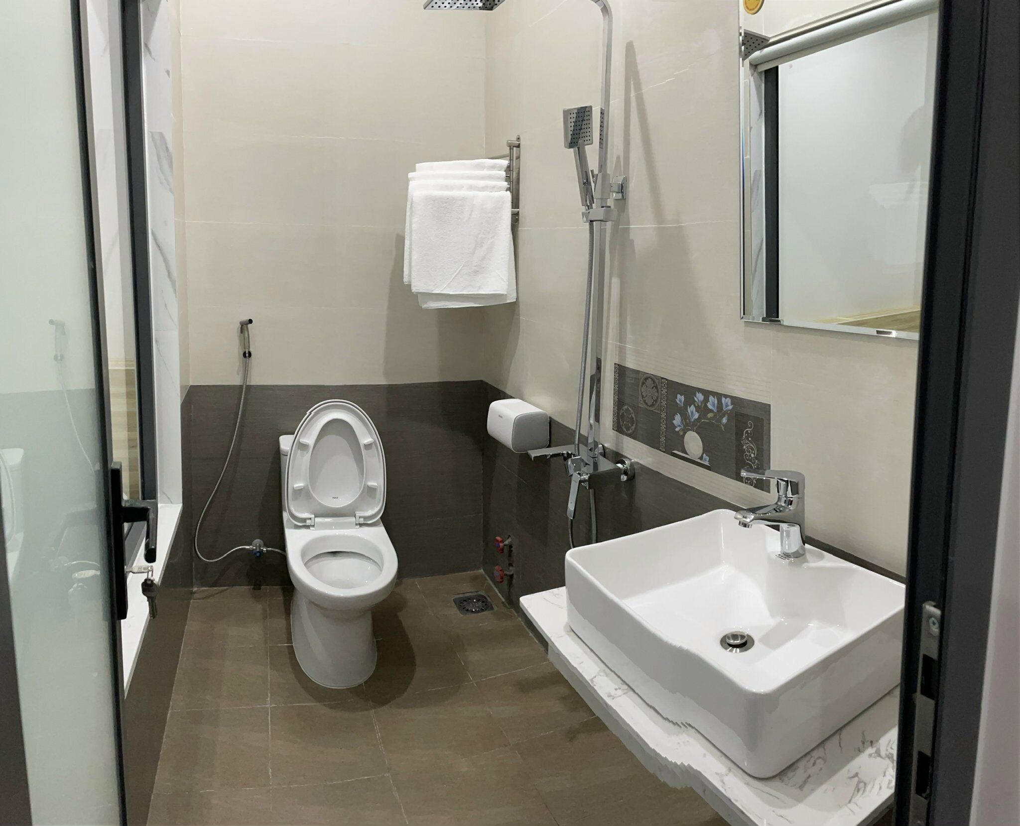 A bathroom with a toilet, a sink, and a shower.