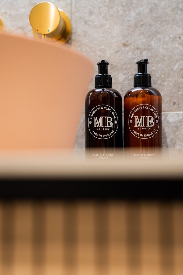 Two bottles of hand wash and body lotion with a gold faucet in the background. - Bob W Lübeck Old Town (Lübeck)