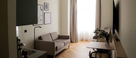 Un soggiorno moderno con un divano, un tavolo da pranzo e una TV a parete.