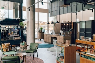 Um café moderno com máquina de café, área de estar e vista para a rua.