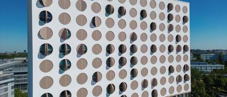 Un edificio moderno con una fachada que presenta una cuadrícula de ventanas circulares.
