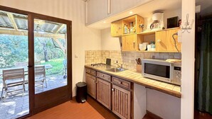 Eine Küche mit Holzausstattung, einer Mikrowelle und einem Spülbecken.