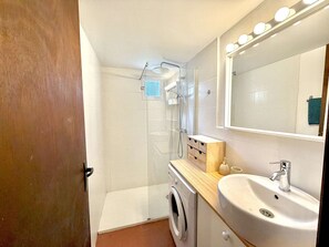 A compact bathroom with a washing machine, a sink, and a shower. - Mini-villa in Porto-Vecchio, near beach, terrace, private parking (Porto-Vecchio)