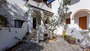 A courtyard with stone flooring, a staircase, and potted plants. - Holiday Apartment "Casa Antonella" with Garden, Balcony & Air Conditioning (Orosei)