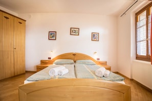 Une chambre à coucher avec un lit en bois, une armoire et trois tableaux encadrés accrochés au mur.
