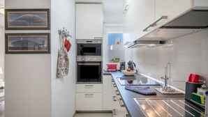A modern kitchen with white cabinets, a stainless steel oven, and a black countertop. - Holiday Home "Alegria" close to the Beach with Garden & Wi-Fi (Puerto del Carmen)