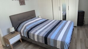 Une chambre à coucher comprenant un lit, une table de chevet, une armoire et des œuvres d’art murales.