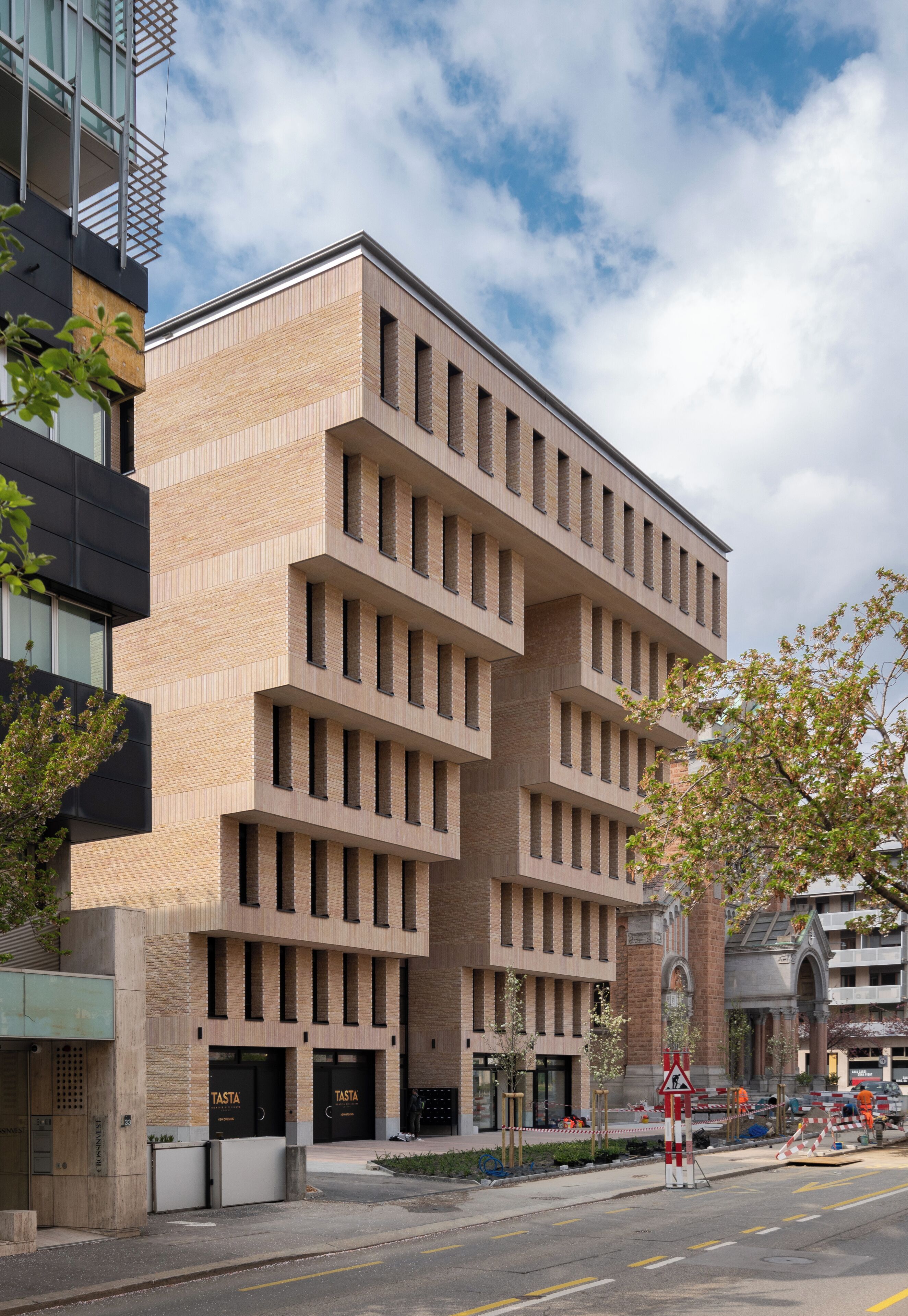 A modern building with a brick facade, multiple windows, and a flat roof.