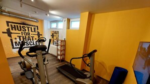 A gym with exercise equipment, a motivational wall, and a wooden floor. - STAY.inn Comfort Art Hotel Schwaz (Schwaz)