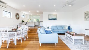 Un amplio salón con una mesa de comedor, un sofá azul y una mesa de centro.