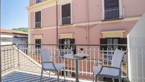 A balcony with two wicker chairs, a small table, and a book. - Neva-Elegant Suite with Balcony in Massa Lubrense center 10 minutes from Sorrento (Massa Lubrense)