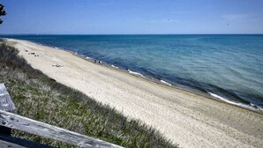 A beach with a wooden fence and a clear view of the ocean.