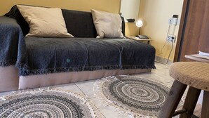 A bedroom with a bed, a nightstand, a lamp, and a chair. - Cozy Studio at Kallithea, Fully Equipped (Nea Smirni)