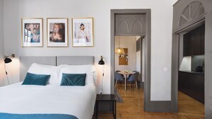 Ein Schlafzimmer mit einem Bett, Nachttischen, einem Schreibtisch und einem Essbereich.