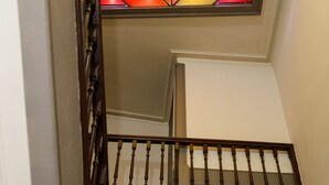 Una escalera de madera con un vitral arriba.