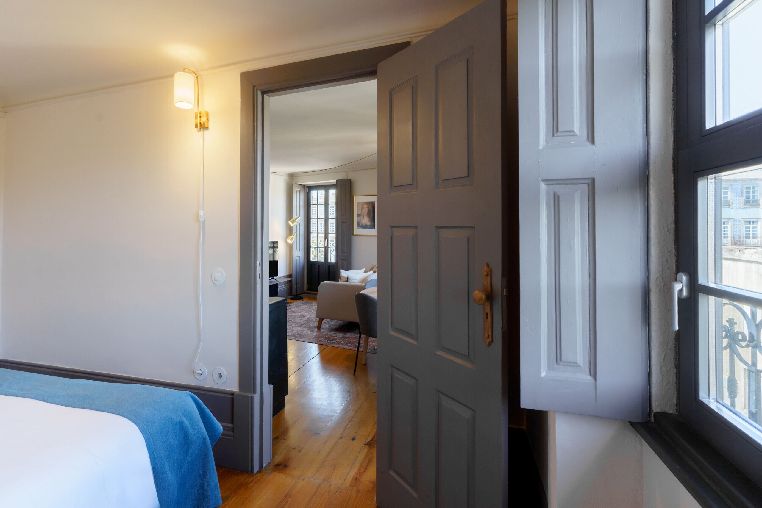 Ein Hotelzimmer mit einem Bett, einem Schreibtisch und Blick auf die Stadt durch ein Fenster.