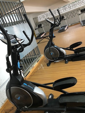 An indoor gym with stationary bikes and a wooden floor.