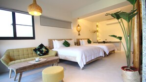 Un dormitorio con una cama, un sofá, una mesa de madera y una planta en maceta.