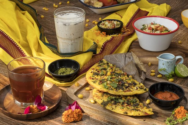 Una mesa con alimentos, una taza de té y un recipiente con salsa.