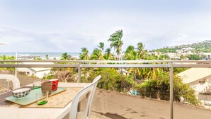 Un balcon avec vue sur la plage et les palmiers.
