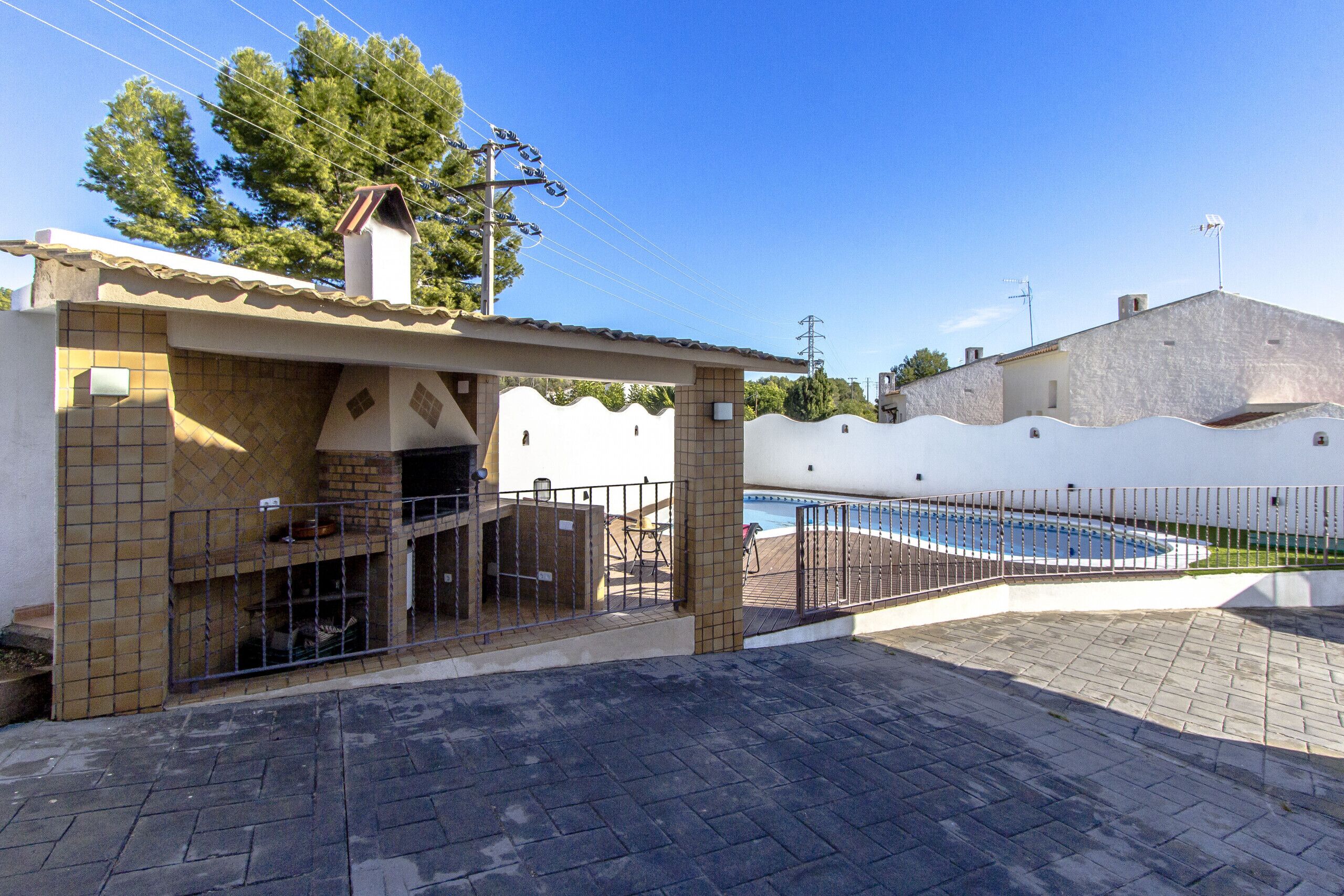 Un espace piscine doté d’une terrasse carrelée, d’un coin salon abrité et d’une piscine clôturée.