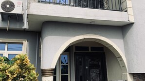 A two-story building with a balcony, an air conditioning unit, and a decorative door. - A Charming 4-bed House in Ibese, Ikorodu (Ikorodu)
