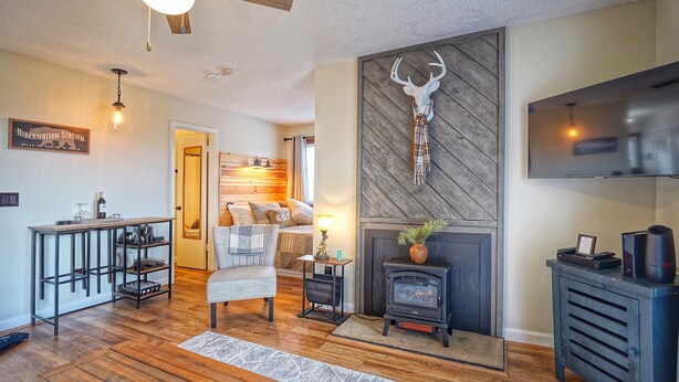 A cozy living room with a fireplace, a mounted deer head, a TV, and a wooden ceiling. - 4308  Hot tub, sauna & more resort amenities  Altitude Adjustment (Beech Mountain)