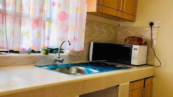 Apartamento conforto, 1 quarto | Cozinha privada | Geladeira, micro-ondas, talheres/pratos/utensílios de cozinha