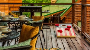 A wooden deck with outdoor furniture, a grill, and a star-patterned table.