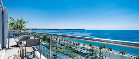 A balcony with a view of a beach and ocean.