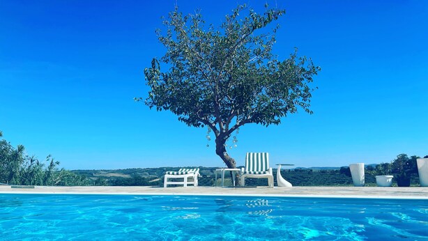 A clear blue pool with lounge chairs and a tree. - 2-bed Apartment in Abruzzo, Italy 15 Minute to sea (Paglieta)