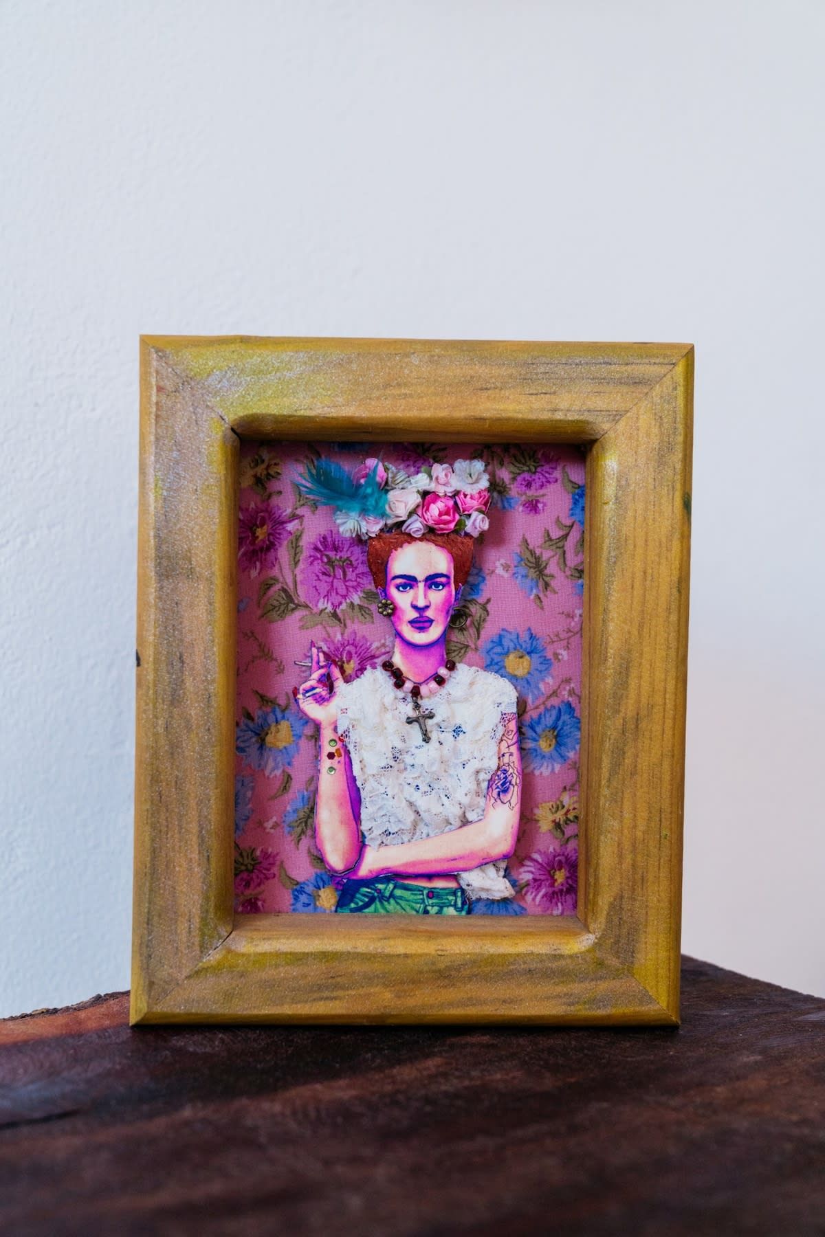 Een lijst met een kunstwerk, waarop een bloemenachtergrond en een figuur te zien is die een bloem vasthoudt.