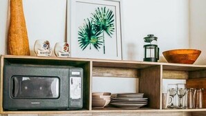 Une cuisine moderne équipée d’un four à micro-ondes, d’une machine à café et d’un évier.