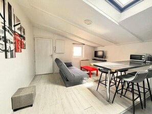 A compact living space with a loft bedroom, a dining area, and a small kitchen. - Comfortable Apartment In Downtown La Rochelle (La Rochelle)